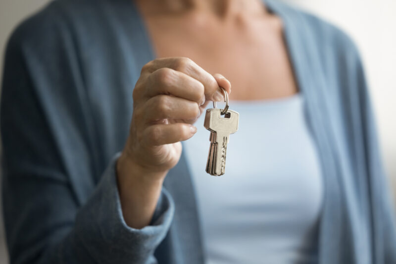 A woman holding up keys.