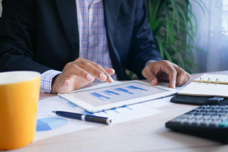 Business man looking at charts on a tablet.