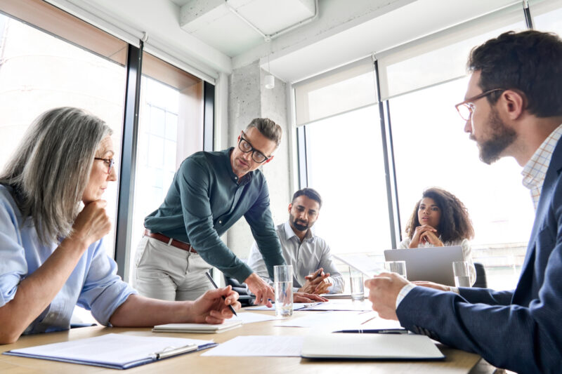 A business meeting taking place around a large table.